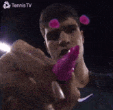 a tennis player is holding a pink object in his hand