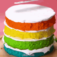 a rainbow cake is stacked on top of each other with easy lus written on the bottom right