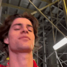 a close up of a man 's face with his eyes closed in a building .