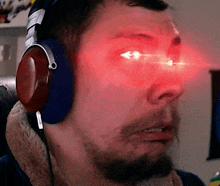 a man wearing headphones has red eyes and a beard