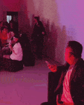 a man is holding a cell phone in front of a crowd