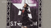 a woman standing in front of a stardom sign