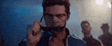a man is holding a pair of sunglasses in front of his face .