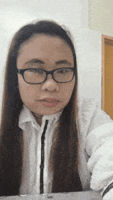 a woman wearing glasses and a white shirt that says l' occitane on the sleeve