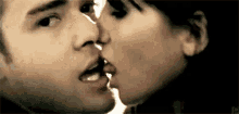 a man and a woman are kissing each other on the lips .