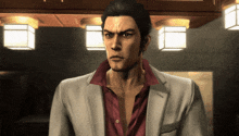 a man in a suit and red shirt stands in a room