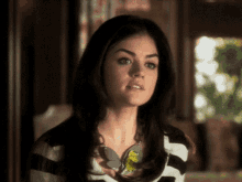 a woman wearing a black and white striped shirt and a necklace
