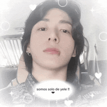 a man with a piercing in his lip is surrounded by hearts and says somos solo de yele !!