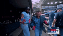 a man in a blue jays uniform is walking towards a dugout