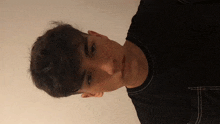a young man with freckles on his face is wearing a black t-shirt