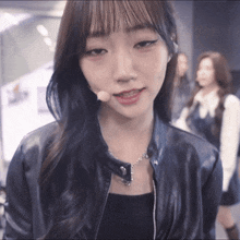 a woman wearing a black leather jacket and a necklace