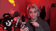 a man with a ring on his finger is pointing to a microphone