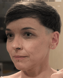 a close up of a woman with a nose ring
