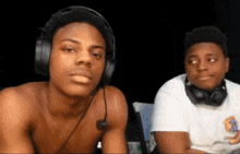 a shirtless man wearing headphones and a microphone looks at the camera