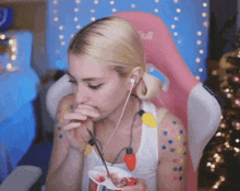 a woman wearing ear buds and a pink chair with the word tuff on it