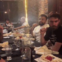 a group of people sitting at a table with a man wearing a t-shirt that says ' a ' on it