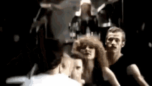 a group of people are dancing in a dark room in a black and white photo .