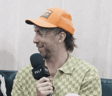 a man in an orange hat is holding a microphone that says pulp