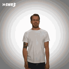 a man with a tattoo on his arm is making a funny face in front of a swr3 sign