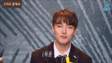 a young man wearing a suit and tie is making a funny face .