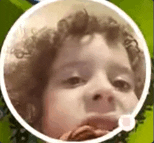 a close up of a child 's face in a circle with a speech bubble .