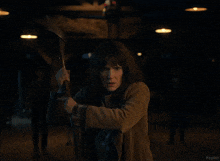 a woman holding an axe in a dark room with kepler written on the bottom right
