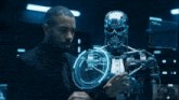 a man in a suit stands next to a robot with a screen behind him that says michael astelz