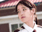 a close up of a woman 's face with a sign that says ' iu ' in the background