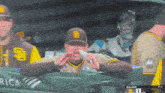 a man wearing a san diego padres hat wipes his mouth
