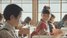 a boy and a girl are sitting in a classroom with the letters nhk on the bottom