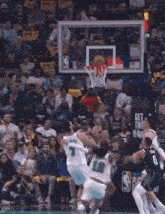 a basketball game is being played in front of a crowd with a sign that says " play in purnama "