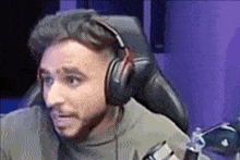 a man wearing headphones is sitting in a chair in front of a computer .
