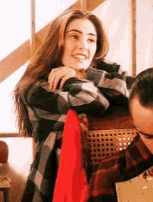 a woman in a plaid shirt is standing next to a man in a red shirt