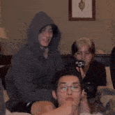a group of young men are sitting on a bed laughing and playing with each other .