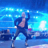a man is dancing in a wrestling ring with a crowd watching