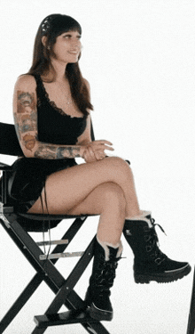 a woman sits in a chair with her legs crossed