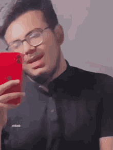 a man taking a selfie with a red iphone