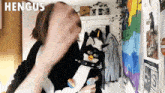 a person is holding a furby in their arms and the word hengus is above them