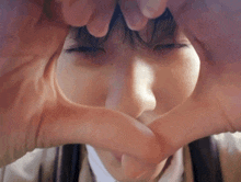 a girl making a heart shape with her hands