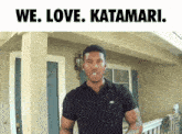 a man in a black shirt stands in front of a house with the words " we love katamari " above him
