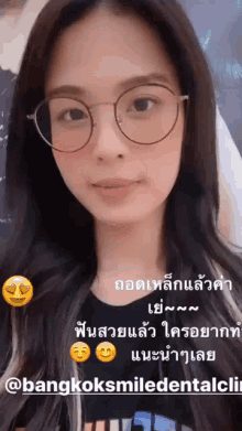 a woman wearing glasses and a black shirt with a bangkok smile dental clinic logo on the bottom