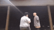 a man and a mannequin are standing next to each other on a stage .
