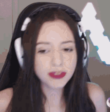 a woman is wearing headphones and making a funny face while sitting in a chair .