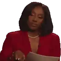 a woman in a red jacket is holding a piece of paper and making a face .