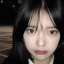 a close up of a girl 's face with long black hair and red lipstick .
