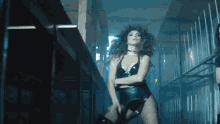 a woman in a tight black outfit is dancing