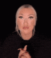 a woman with blonde hair is making a funny face with her hands in the air .