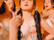 a group of young women are dancing together and one of them has pigtails .