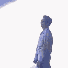 a man in a white jacket is standing on a stage holding a microphone and dancing .