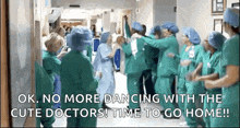 a group of doctors are dancing together in a hospital hallway
